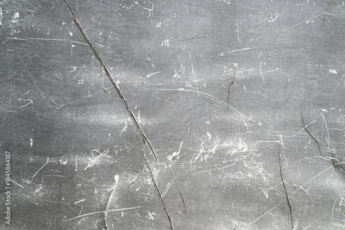 Fotografia Texture of a gray scratched metal or plastic surface with cracks and abrasions