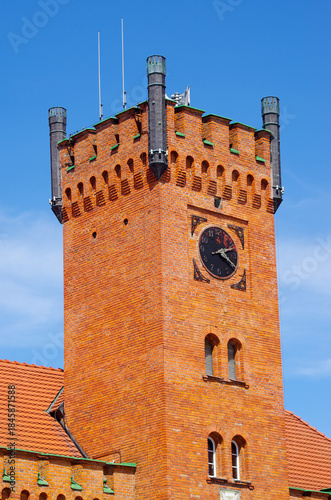 Historic brick clock tower with blue sky background, Swinoujscie, Poland