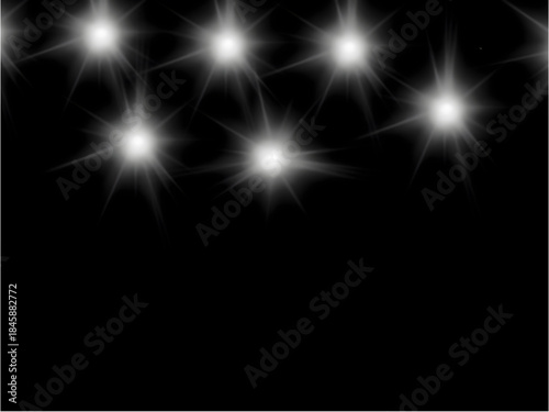Sparkling white starburst lights on black background