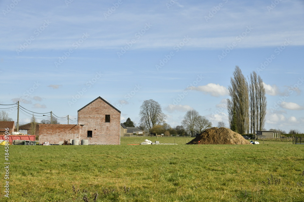 Fototapeta premium Maison en construction dans une prairie à Hellebecq (Silly)