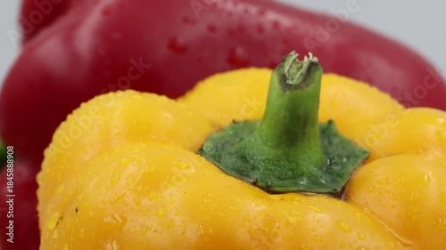 This close-up shot features fresh red and yellow bell peppers slowly rotating on a turntable. 