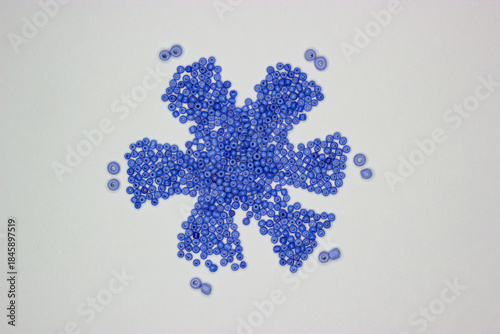 Beads snowflake. The beads are arranged in the shape of a snowflake. Blue beads. Beads for jewelry, embroidery, handmade, craft. Hobbie materials. Winter, Christmas theme
