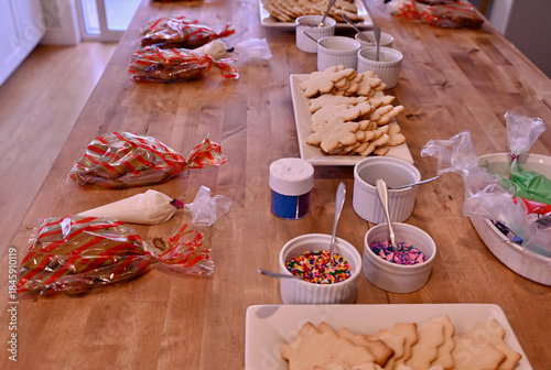 Homemade Christmas sugar cookies set up for themed Daddy Daughter cookie decorating holiday party with sprinkles, icing and coloured sugar