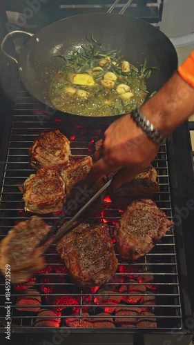 close-up footage of grilling steaks, barbecue party in evening, the meat is stewed in butter with garlic and thyme, spiking pieces of meat on the grill, various vegetables, lots of smoke