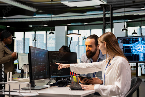 Friendly team leader mentor explaining young software engineer how to use AI tech. Joyous supervisor guiding office newcomer through AI tool integration, mentoring her on using neural networks APIs