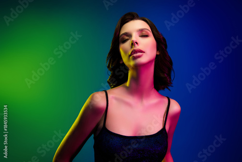 Charming young woman posing under vibrant neon lights in chic attire, evoking elegance and a contemporary fashion