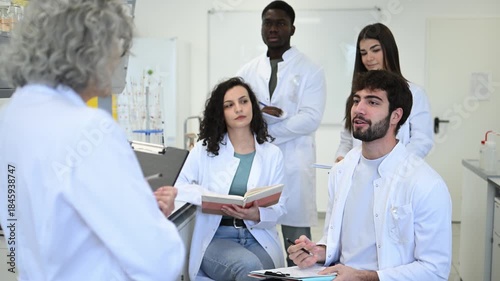 Professor teaching multicultural science students in university laboratory class
