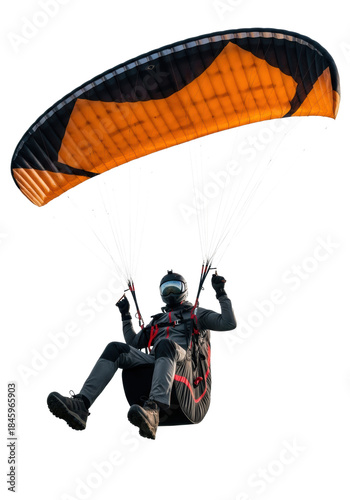 athletic male pilot in a high-tech suit and black helmet, suspended under a vast orange and black paraglider wing; sharp studio lighting against transparent background. concept of extreme