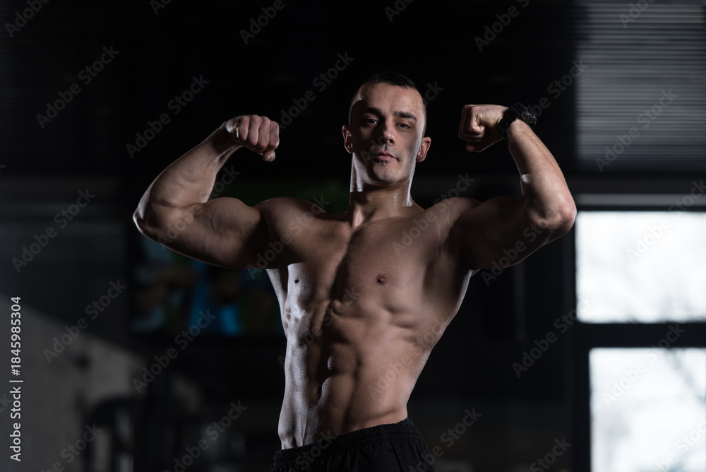 Fototapeta premium Bodybuilder Fitness Model Posing Double Biceps After Exercises