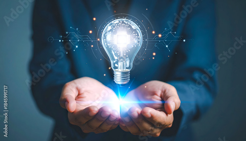 Artificial intelligence and innovation concept showing a digital light bulb hologram above human hands, representing smart ideas, technology growth, and future solutions.