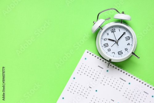 Calendar with alarm clock on green background