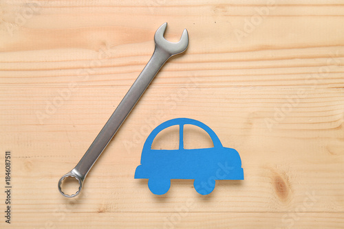 Wrench and toy car on woode...