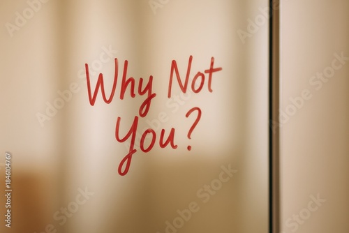Motivational phrase why not you written on glass with blurred background