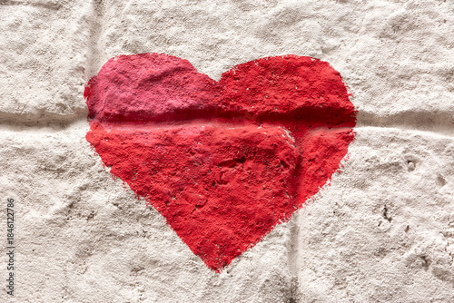 Red color heart shape painted on concrete background