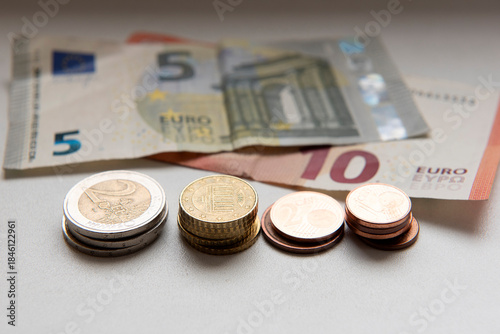 Euro coins with five and ten Euro bills on table