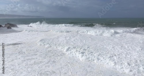 Wallpaper Mural Aerial drone shot of big waves coming into shore on a day with giant waves in Nazaré, Portugal, Europe. Jet ski riders and surfers in Atlantic Ocean. Big wave surfing town Torontodigital.ca