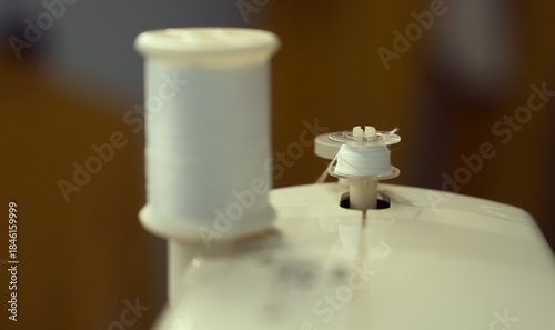 The bobbin is threaded with white thread on the sewing machine.