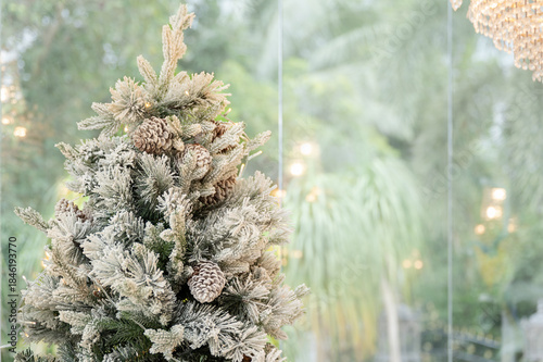 Blue Christmas tree with snowflakes falling on its branches