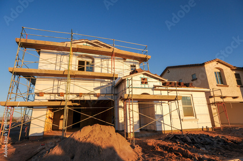 Wallpaper Mural Two-story homes under various stages of construction with scaffolding, exposed framing, and exterior finishing work, illustrating active residential development and phased homebuilding operations Torontodigital.ca