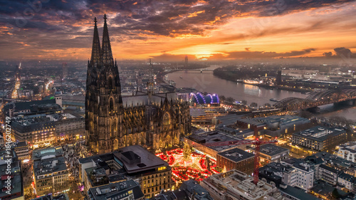 Aerial view of the Cologne Cathedral Christmas Market (Weihnachtsmarkt am Kölner Dom) on Roncalliplatz at sunset - Holiday celebrations in Germany