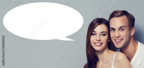 Love, relationship, lovers, romantic dates concept - expressive happy couple. Portrait of young man woman, isolated grey gray background with white empty mockup speech bubble, free ad text space