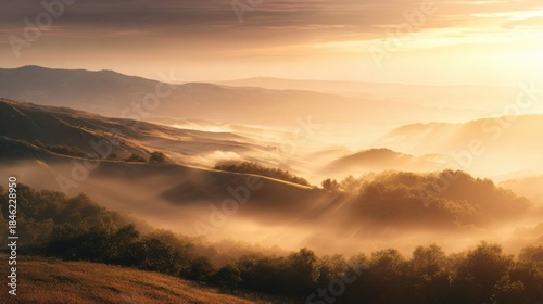 Wide valley filled with golden mist at sunrise, rolling hills emerging through fog, warm sunlight cutting through layers of atmosphere, peaceful