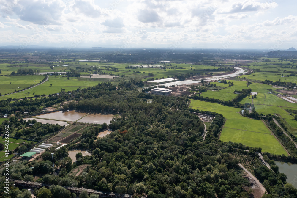 Obraz premium Top view of the Sakae Krang River, Uthai Thani Province where both sides of river are filled with lush green trees. There are community near waterside.