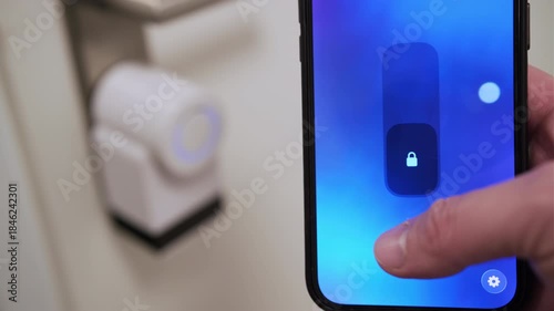 Close up of a man using a smartphone app to lock a smart door lock remotely.