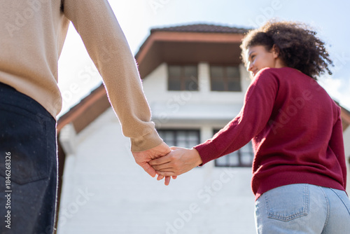 Close up of Latino young couple walking in front of their new house.