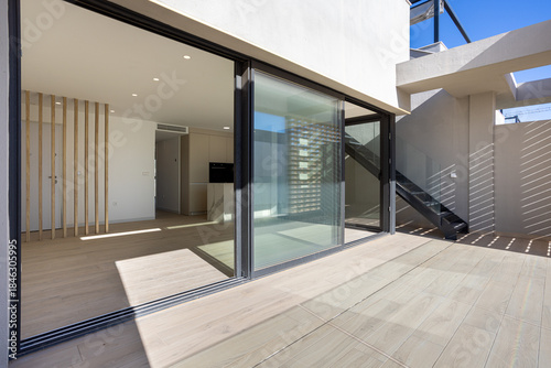 Modern open interior with terrace access and architectural staircase feature