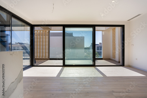 Modern living room with large sliding glass doors and sunlight