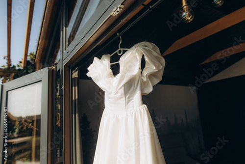 White wedding dress hanging for bridal preparation