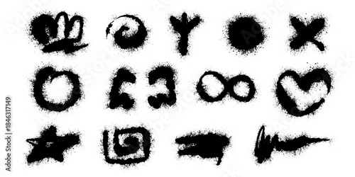 Elements of spray graffiti on a wall with monochrome designs and paint splatters in an urban setting.