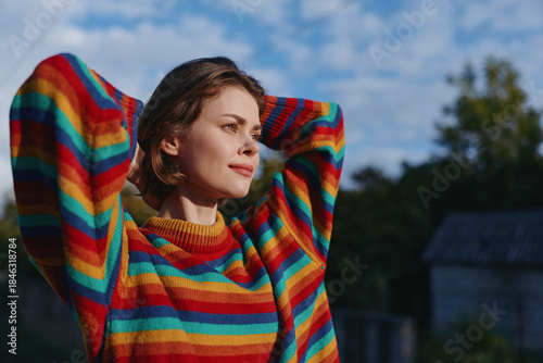 Bild auf Leinwand Young woman striped sweater outdoors relaxed smiling casual outfit nature countryside with hands behind head, colorful fashion portrait in soft natural light for lifestyle travel