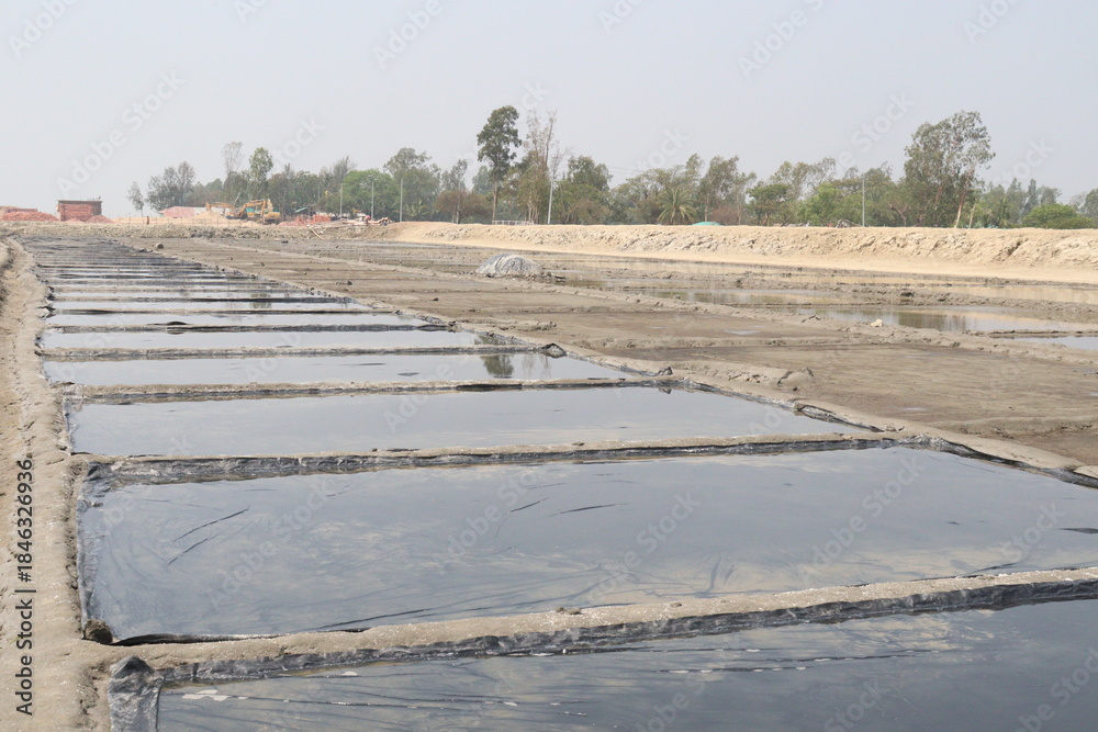 Fototapeta premium raw salt farm plot with water and polythene bed