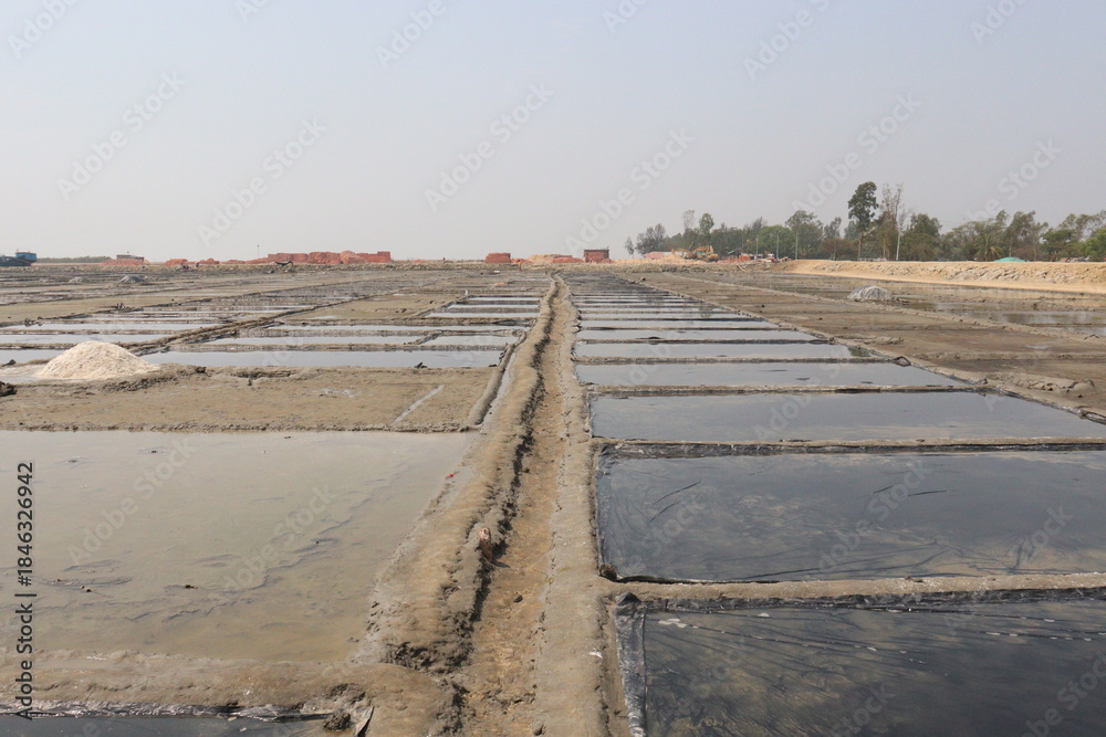 Fototapeta premium raw salt farm plot with water and polythene bed