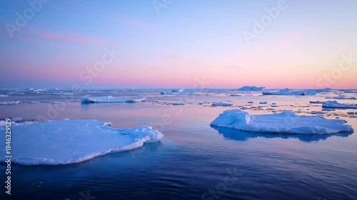 Ice floes drift on the arctic waters at sunset with a soft light