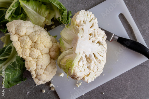 Preparing fresh cauliflower with knife, cooking concept