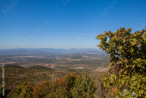 Panoramic view from the top of Mount Križevac in Medjugorje with the iconic cross overlooking the town, a sacred pilgrimage site symbolizing Christian faith, prayer, and spiritual reflection.
