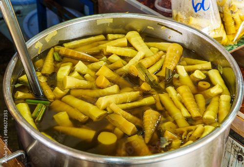 Photos Pickled yellow bamboo shoots in brine soup inside large metal pot at Thai fresh market
