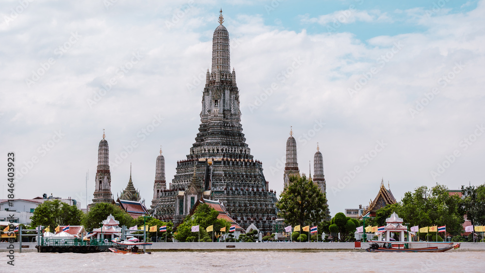Obraz premium Sunrise over Wat Arun temple in Bangkok reflecting on the river, showcasing Thailands beauty