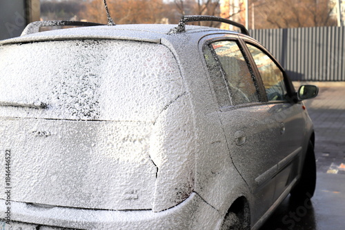 Gray car at self-service car wash. Washing car