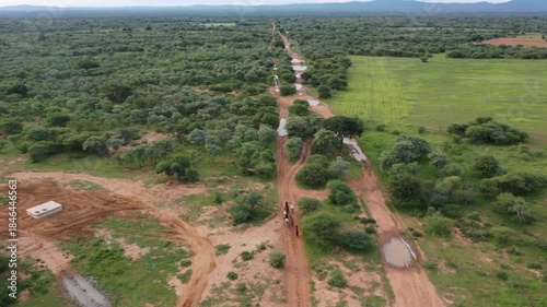 African horseback safari , African man and woman riding group of horse herd through the bush, trail riding in Botswana, Africa.