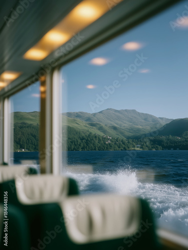 Scenic view of mountains and lake from inside a ferry with empty seats, peaceful travel moment