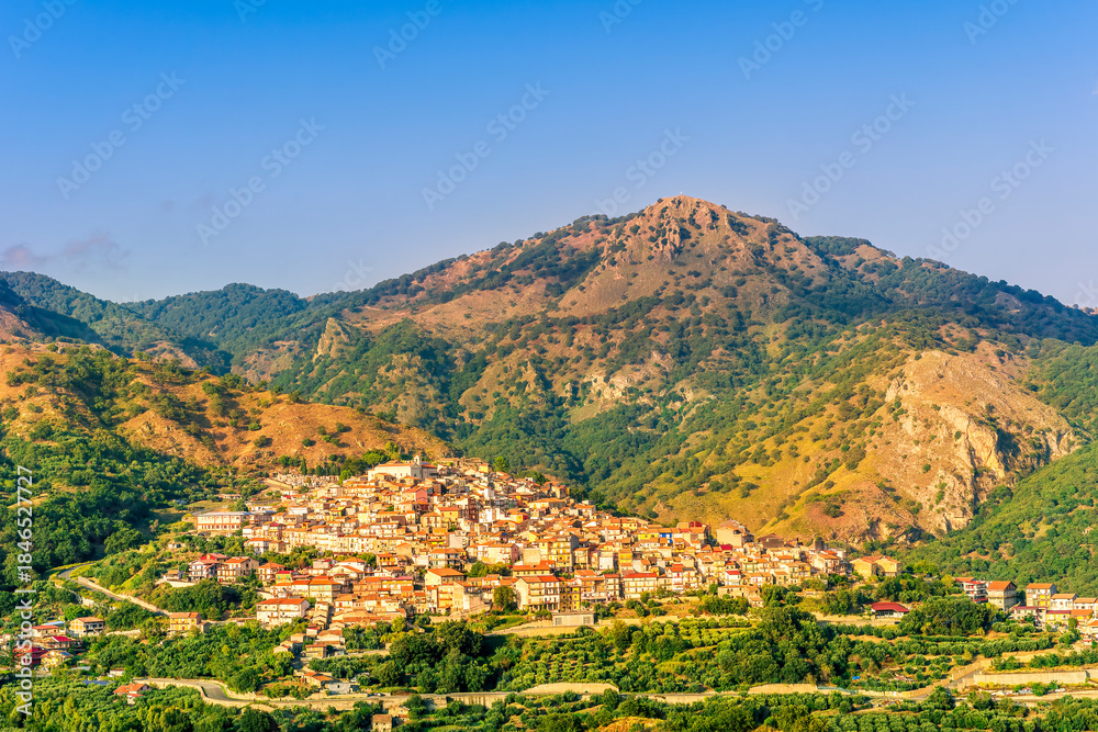 Obraz premium highland landscape of italian town between amazing green mountains with scenic sunset cloudy sky on background