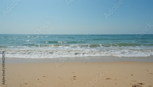 A clear horizon, soft waves, and a sandy beach backdrop