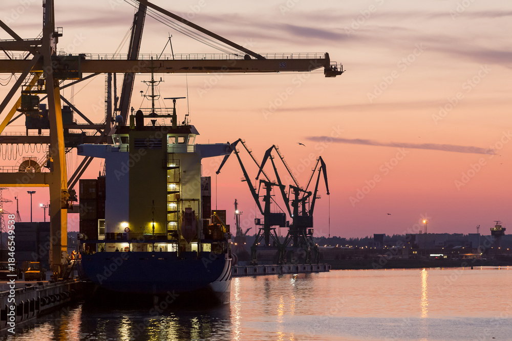 Obraz premium Klaipeda Port at Sunset with cargo ships and industrial cranes, Lithuania