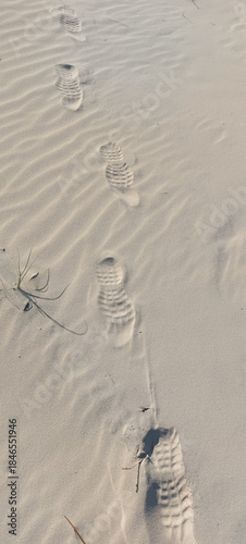 Footprints in the sand on the beach, closeup of photo