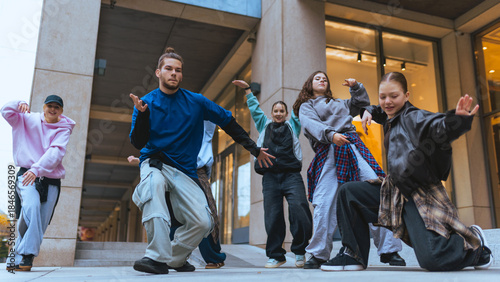 Photos Group of street dancers practicing expressive moves in city plaza setting