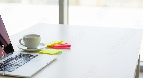 Clean minimalist workspace with laptop, coffee cup, and colorful sticky notes.